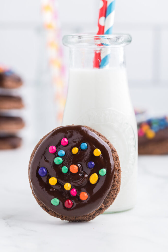 one cosmic brownie cookie resting up against a glass milk container