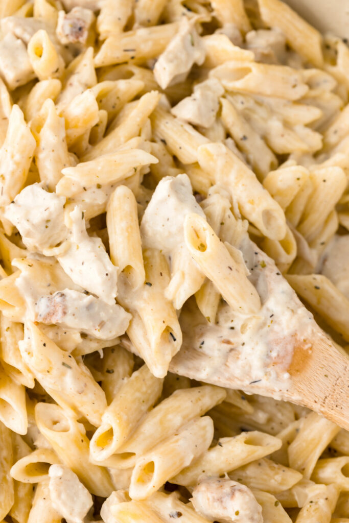 one pot chicken pasta in pan with wooden spoon