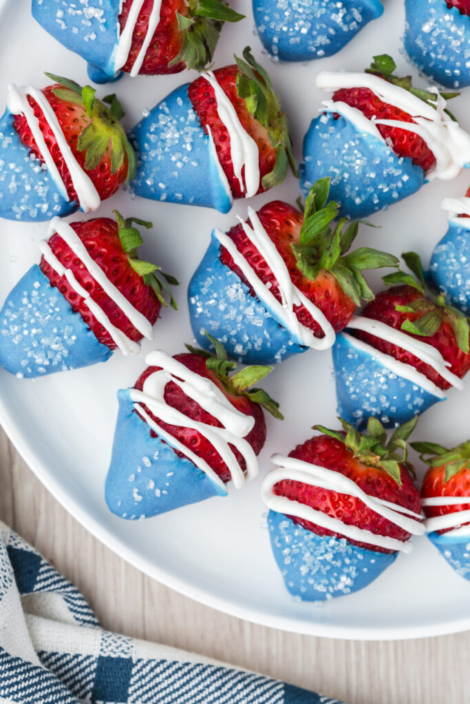 red white and blue decorated strawberries fanned out on serving platter